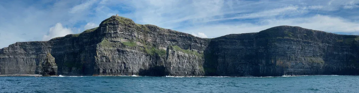 The Cliffs of Moher seen from a cruise boat below O'Brien's Tower, the sea view on a Cliffs of Moher tour from Dublin, Ireland